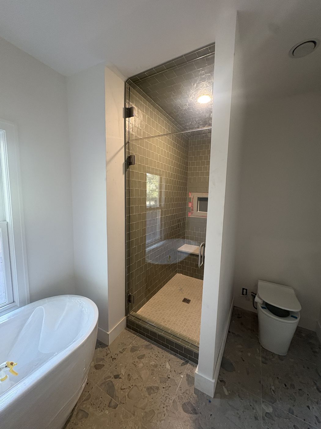 Frameless steam shower door with fixed transom above