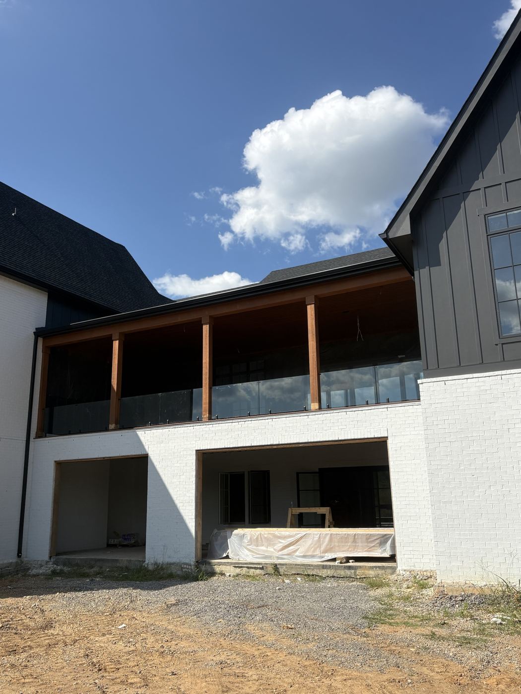 Frameless glass railing along a second-story covered porch