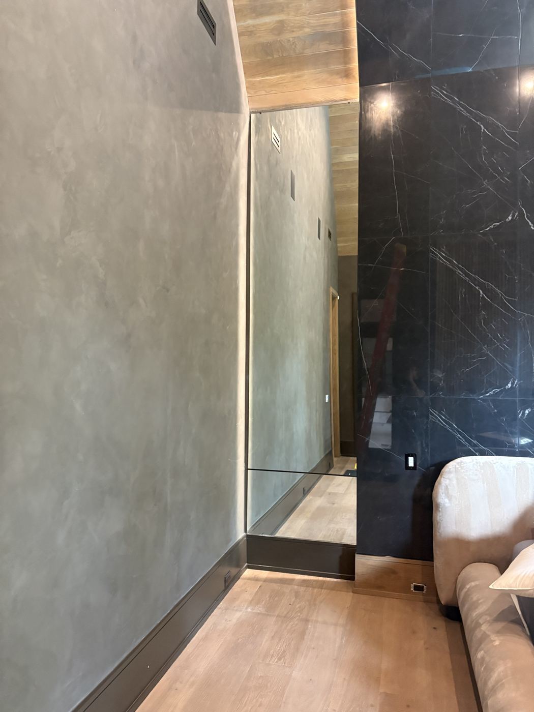 Full-height custom mirror set into a plaster wall